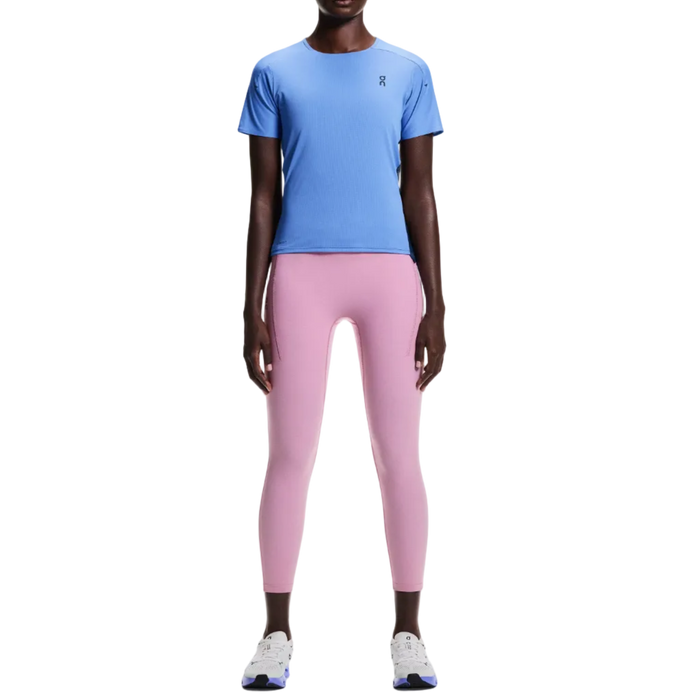 Person wearing a blue athletic shirt and pink leggings on a white background